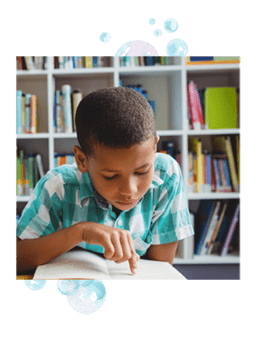 A boy reading with his finger. Kids with dyslexia are tactile learners, which affects reading abilities.