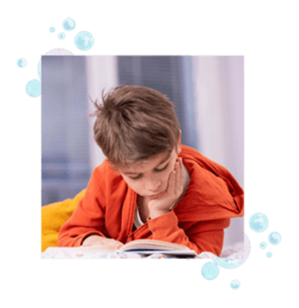 A boy reading on a bed. 