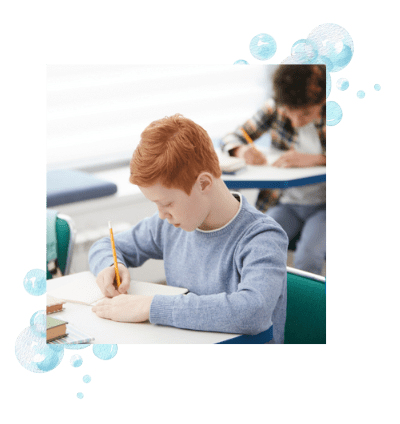 A boy writing in class after learning to use proper spatial visual skills.