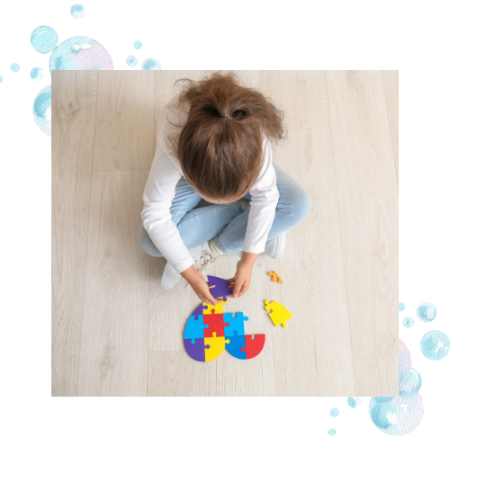 A child doing a floor puzzle, which is a great activity for making spatial visual skills strong.