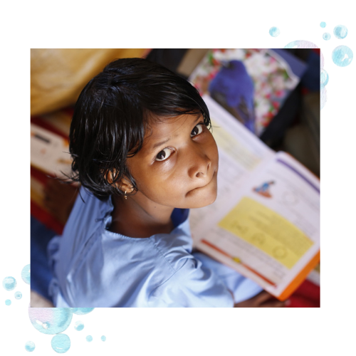 A girl staring away from a book. She is struggling to read because her visual motor integration skills are weak.