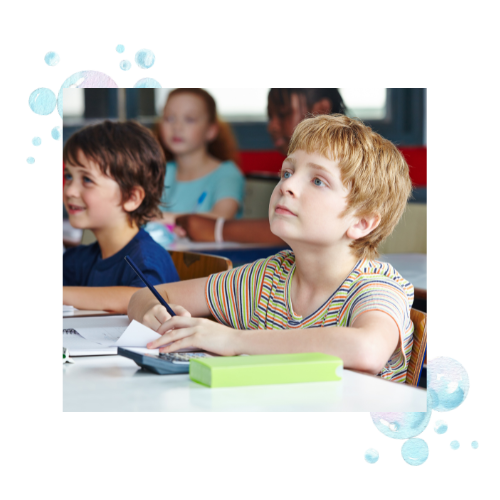 A boy paying attention in school. He is working on a calculator, something that requires visual motor integration skills.